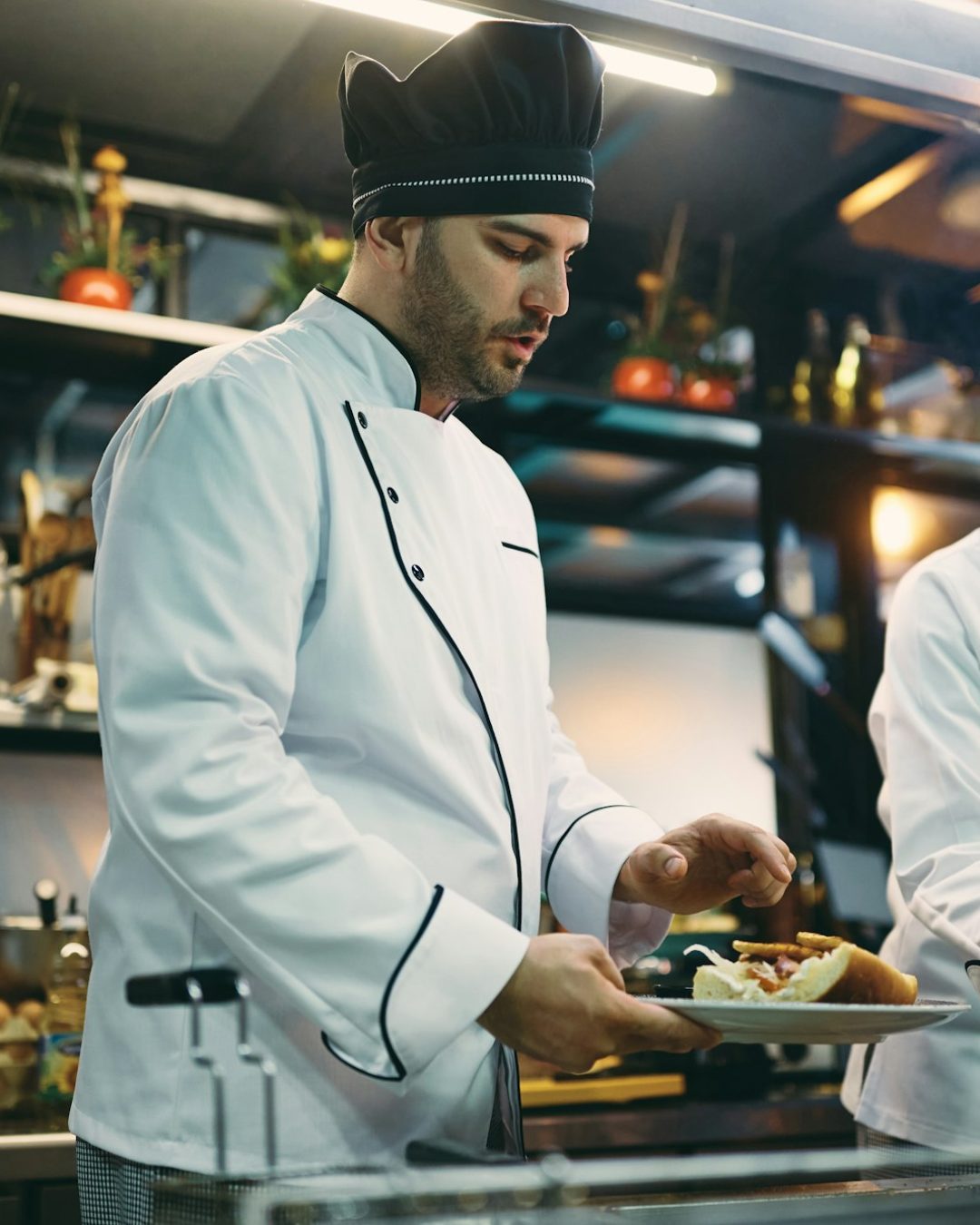 Two chefs cooperating while preparing meal in a restaurant.