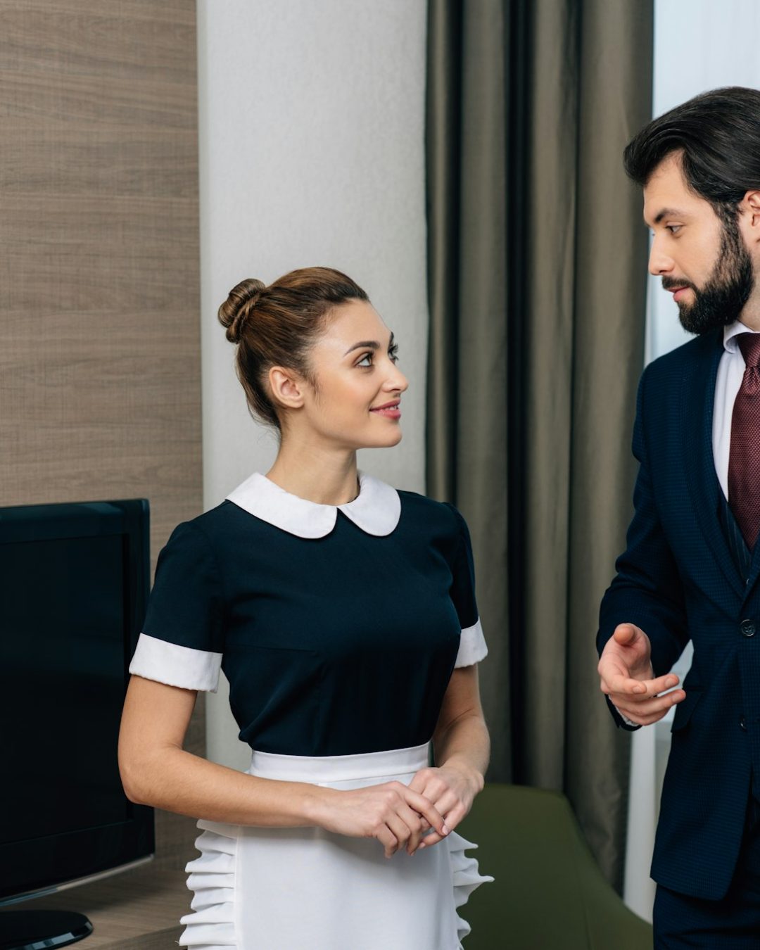 young hotel service staff talking at suite